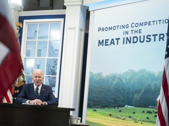 Joe Biden at a desk, next to him a full screen poster "Promoting Competition in the Meat Industry"