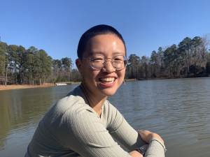 Photo of Katherine Gan sitting in front of a body of water