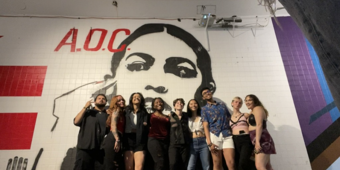 A group of students in front of a mural of Alexandria Ocasio Cortez