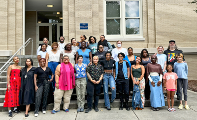 Students and faculty in front of building on outside steps