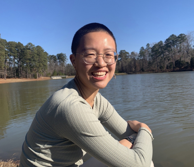 Photo of Katherine Gan sitting in front of a body of water