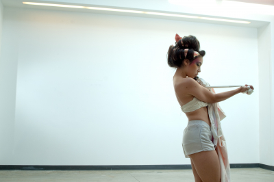 A performer pulls fabric away from her chest