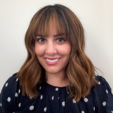 Woman with Long brown hair black top with white pocodots